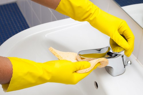 Domestic cleaner tidying a kitchen in a Hammersmith flat